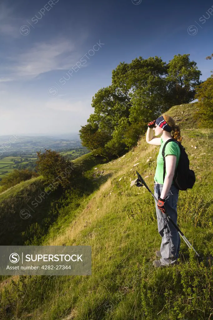 Wales, Powys, Brecon. A young woman admiring the view from Castell Dinas on the Pengenffordd pass in the Brecon Beacons National Park.