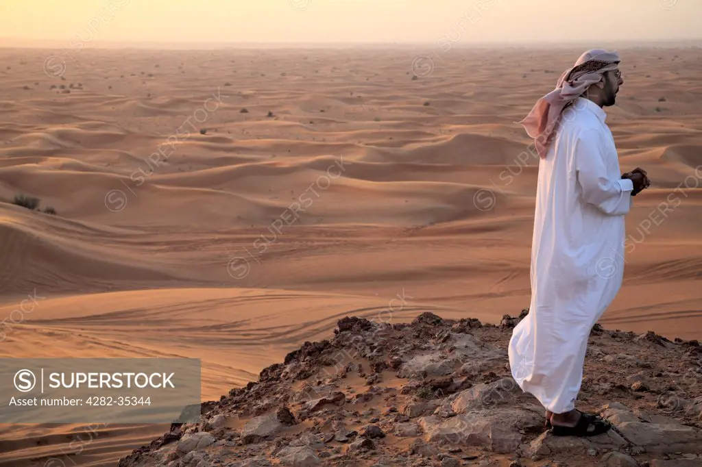 United Arab Emirates, Dubai, Dubai Desert. A man looks out into the Dubai desert.