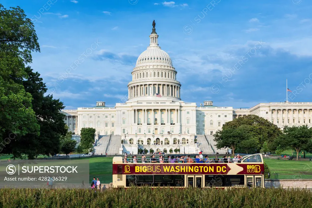 USA, District of Columbia, Washington DC. A tour bus travels past the US Capitol Building in Washington DC.