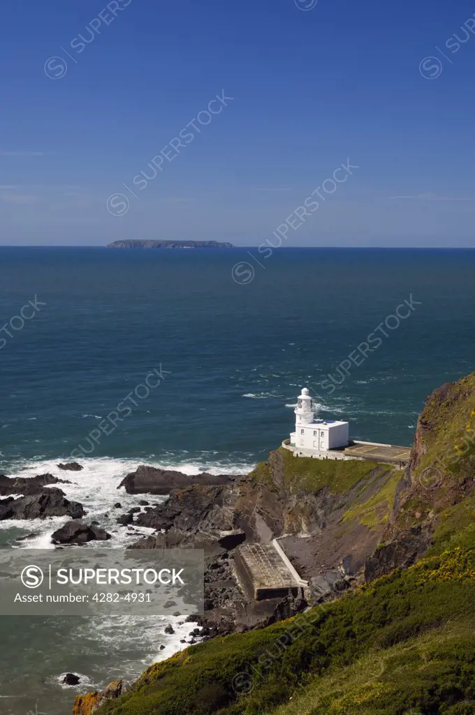 England, Devon, Hartland. Hartland Point lighthouse on the North Devon Coast with Lundy Island on the horizon.