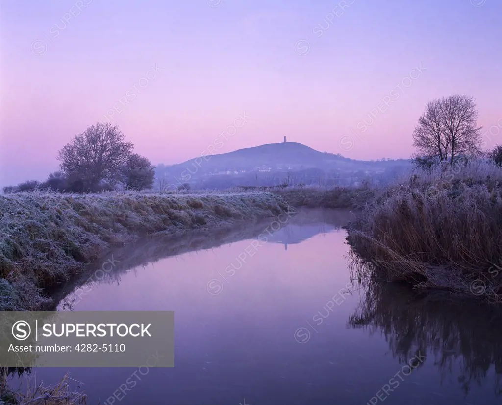 England, Somerset, Glastonbury. The River Brue on South Moor on the Somerset Levels at Glastonbury with Glastonbury Tor in the distance, Somerset.