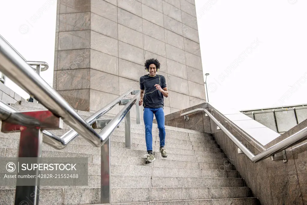 A young man limbering up for a jog along the South Bank in London.