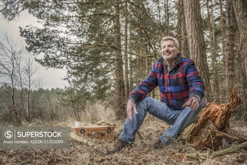 Senior man sitting enjoying the wilderness from his campsite.