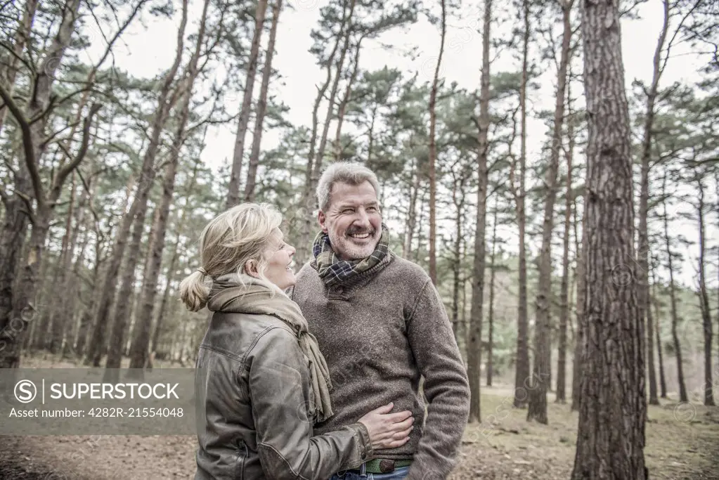 Senior couple enjoying a break during a woodland walk.