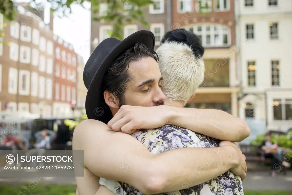 A gay couple hug each other.