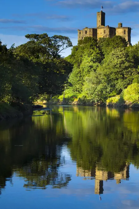 England, Northumberland, Warkworth. Warkworth Castle reflected in the still waters of the River Coquet.