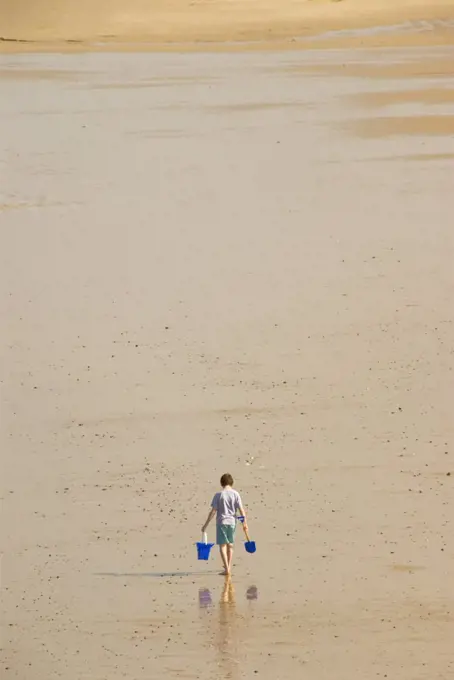 England, Norfolk, Cromer. A view of the sandy beach at Cromer and a lone figure. This area is part of the Holkham Estate and there are vast unspoiled beaches and woodland areas.