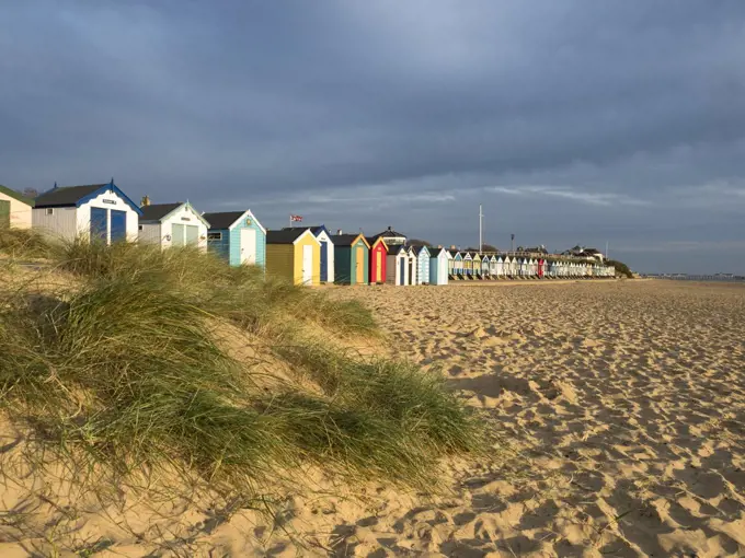 Southwold beach huts behind sand dunes.