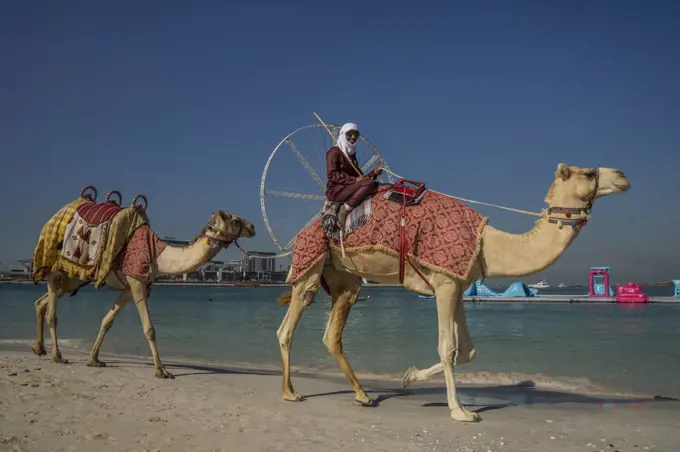 A Bedouin man smiles as he passes in front of Ain Dubai which is the world's largest ferris wheel on Jumeirah Beach in Dubai.