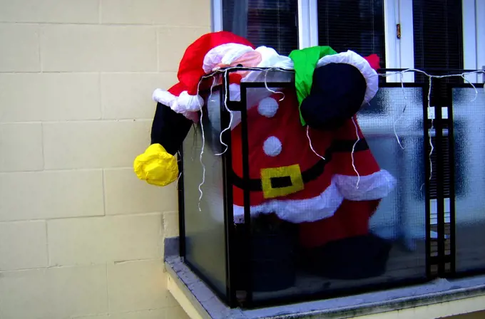 England, City of Brighton and Hove, Hove. A large, partly deflated inflatable Santa on a balcony in Hove.