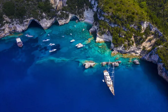 Aerial picture of a private sailing yacht in a secluded beach in Greece.