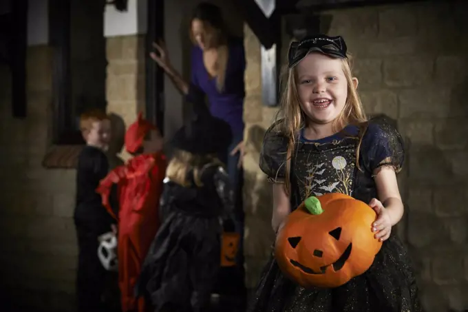 Halloween Party With Children Trick Or Treating In Costume