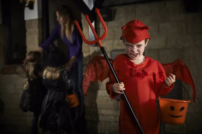 Halloween Party With Children Trick Or Treating In Costume