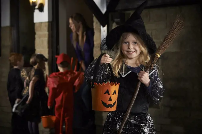 Halloween Party With Children Trick Or Treating In Costume