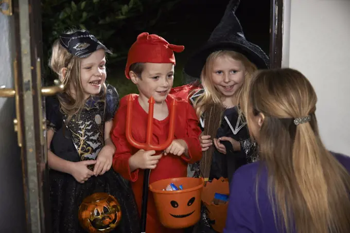 Halloween Party With Children Trick Or Treating In Costume