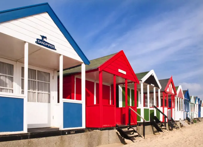 England, Suffolk, Southwold. Colourful beach huts along the seafront in Southwold.