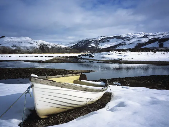 Scotland, Highland, Glenelg. Boat by the Glenmore river estuary in Galltair, with snow on the ground in late winter.