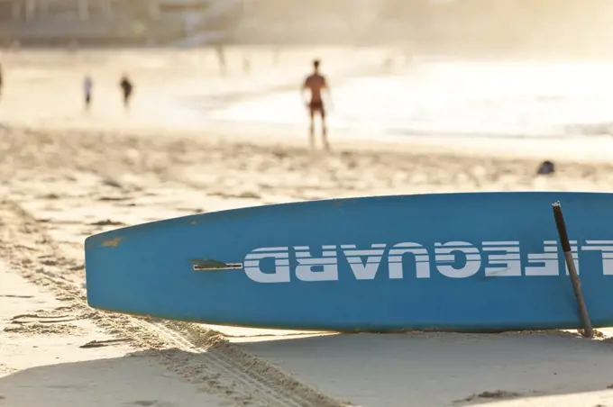 A view of a lifegurad's surf board on Bondi beach at dawn.