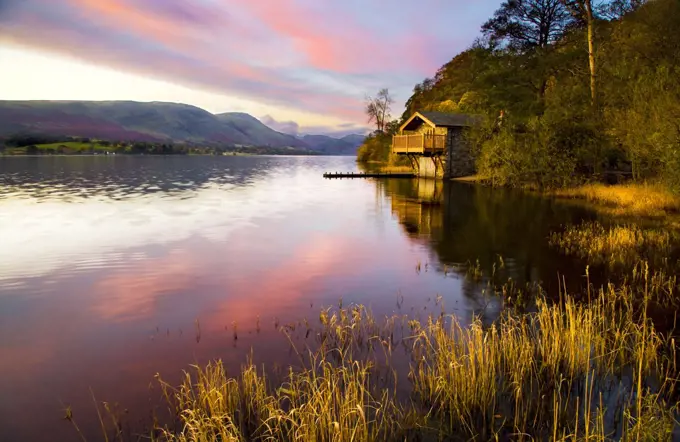 Early morning light falls on a boathouse near Pooley Bridge on the shores of Ullswater.