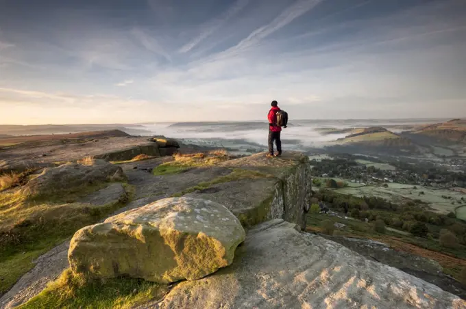 A walker looking across the valley at Curbar Edge.