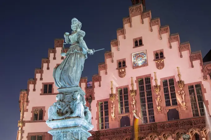 The Justice Fountain or Lady Justice in front of the Town Hall at night in The Romer.