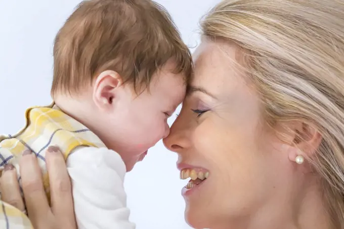 A happy mother and baby face to face.