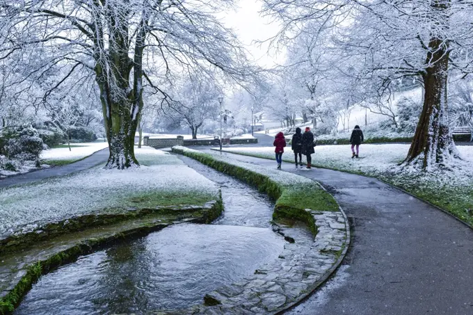 People enjoying a walk in the snow in Trenance Gardens in Newquay in Cornwall.