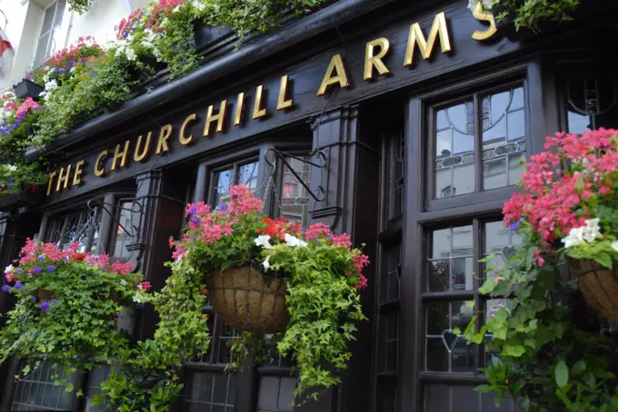 England, London, Notting Hill. Hanging flower baskets on the exterior of Churchill Arms pub in Notting Hill.