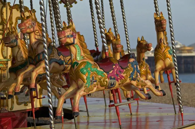 England, East Sussex, Brighton. Detail of Painted Horses on a Merry-Go-Round. This amusement ride, also called a carousel, consists of a rotating platform with seats for passengers in the form of wooden horses or animals.