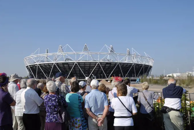 England, London, Stratford. Tourists viewing the Olympic Stadium in Olympic Park.