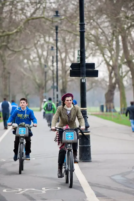 England, London, Hyde Park. Two cyclists riding through Hyde Park in London.