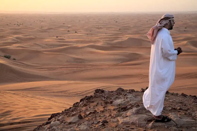 United Arab Emirates, Dubai, Dubai Desert. A man looks out into the Dubai desert.