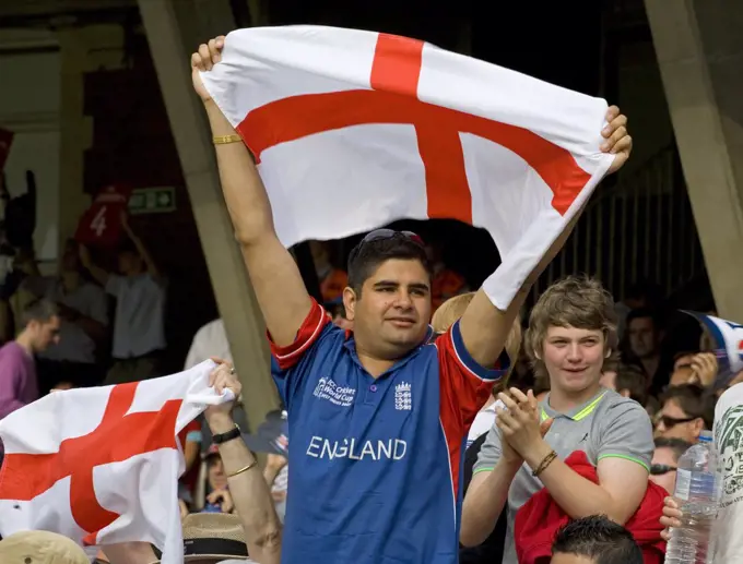 England, London, London. An England cricket fan supporting his team by holding a St George's flag aloft.