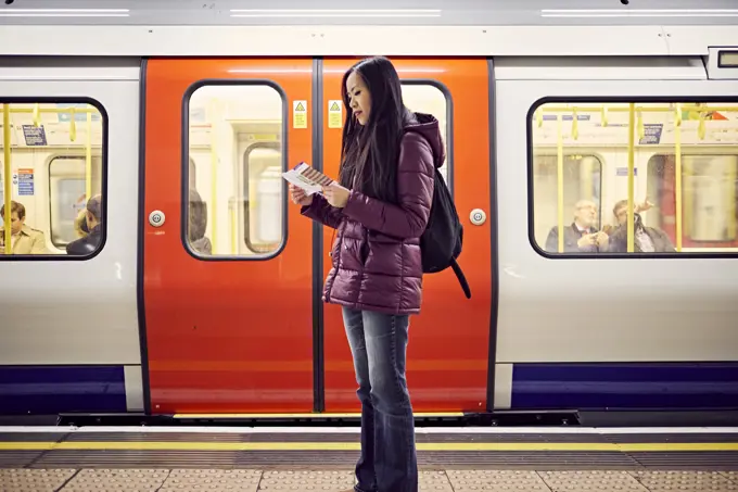 A young Japanese woman at a tube station  in London.