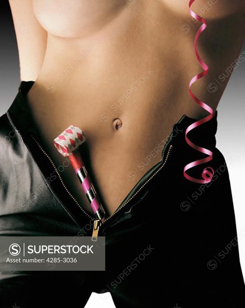 Girl naked torso and belly button, tanned, with black leather shorts,  zippered down, with party streamer and party whistle. - SuperStock