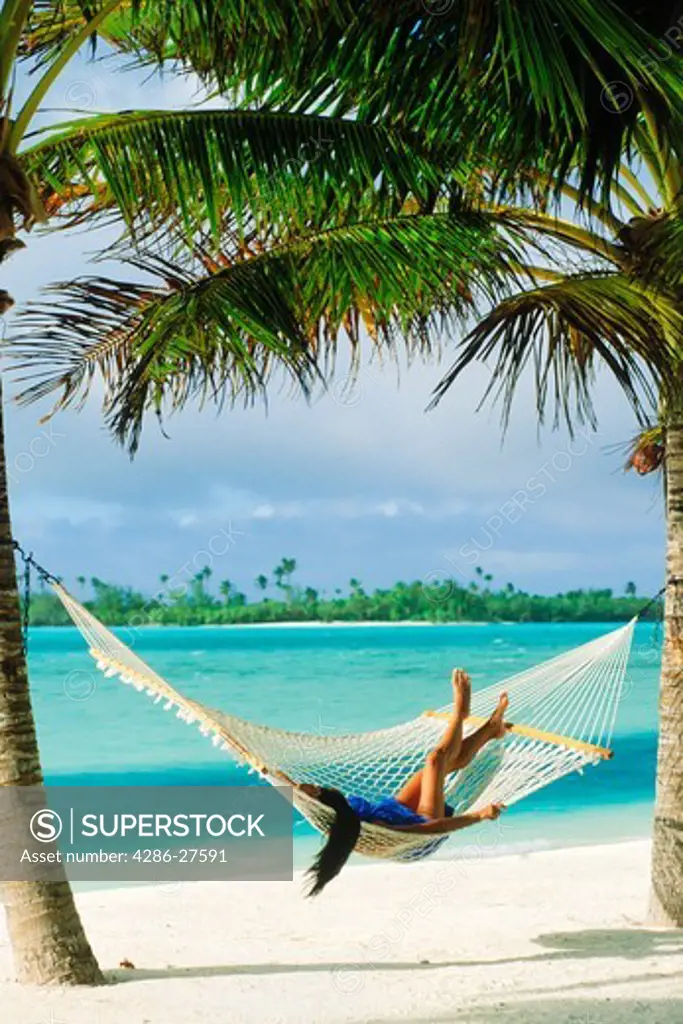 Woman lying in hammock on Aitutaki lagoon in South Pacific