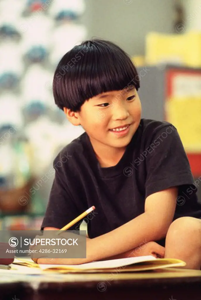 Asian boy in first grade working on an assignment. 