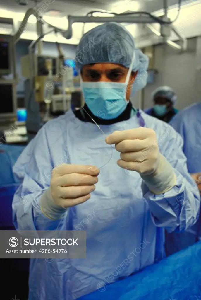 Dr. Fayaz A. Shawl, interventional cardiologist, holds Rotablator catheter (with diamond-studded burr on tip), which is used for PTCRA (Percutaneous Transluminal Coronary Rotational Atherectomy), in cardiac catheterization lab in Maryland.