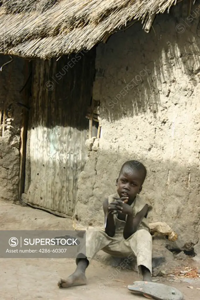 A boy sits in front of a hut ('tukul') in the Rumbek market, South Sudan. NOT MODEL RELEASED. EDITORIAL USE ONLY.