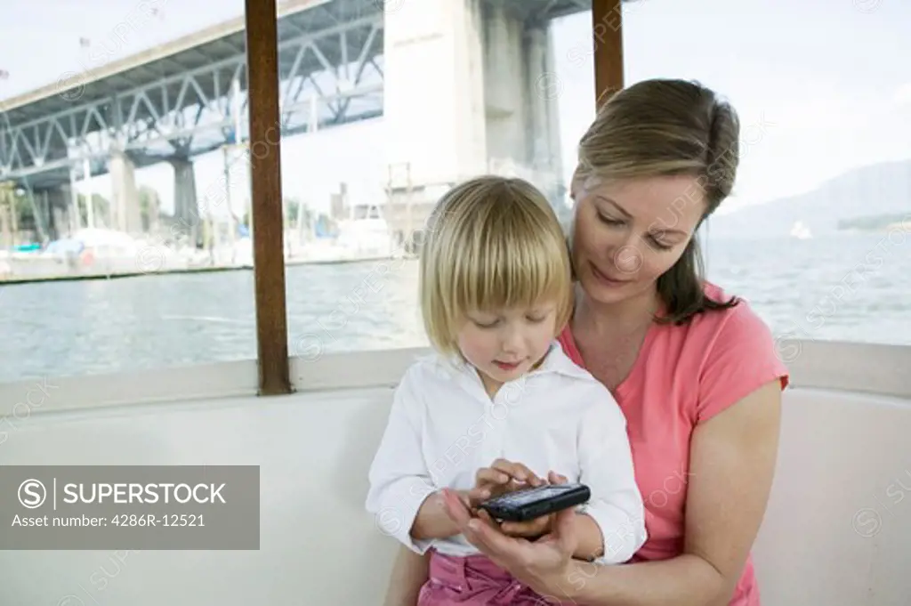 Mom and Daughter With Blackberry Device. Small Commuter Ferry, Granville Island Vancouver, MR-0601 MR-0637