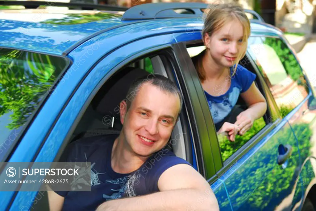 Father and daughter sitting inside the car ready to go on family trip