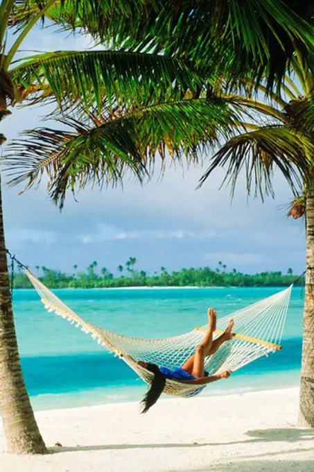 Woman lying in hammock on Aitutaki lagoon in South Pacific