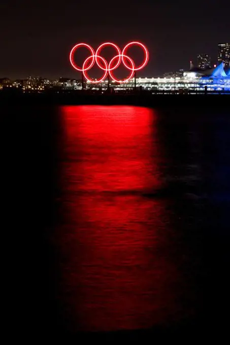 Red glowing Olympic rings refelcted in the harbour during the 2010 Winter Olympic Games, Vancouver, Canada