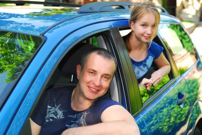 Father and daughter sitting inside the car ready to go on family trip