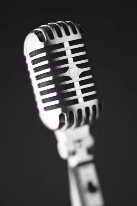 Classic retro microphone on black background, selective focus