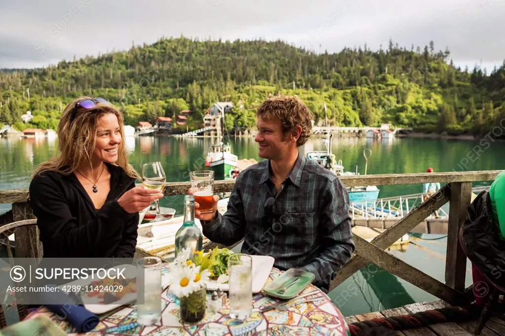 A couple in their 30's enjoys dinner at the Saltry Restaurant in Halibut Cove, Kachemak Bay, Southcentral Alaska.