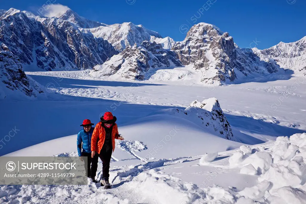 Asian couple walking on a trail in the Ruth Amphitheater with Mt. McKinley and Mt. Dan Beard in the background, Denali National Park, Interior Alaska