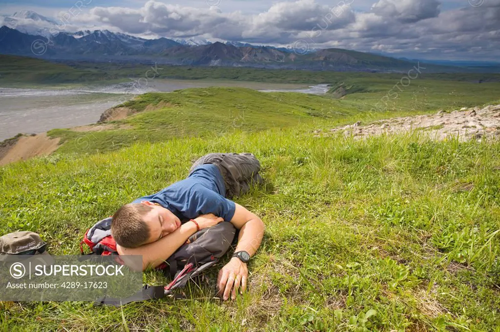 Male hiker sleeps on the tundra at Grassy Pass near the Eielson visitor center Denali National Park Alaska