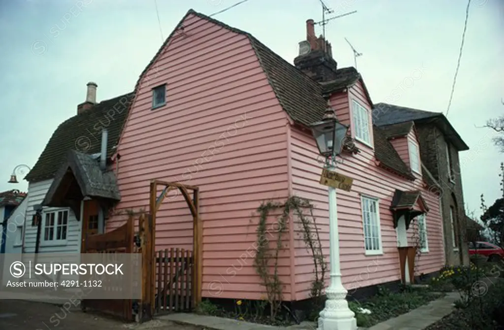 Pastel pink clapboard cottage in country village