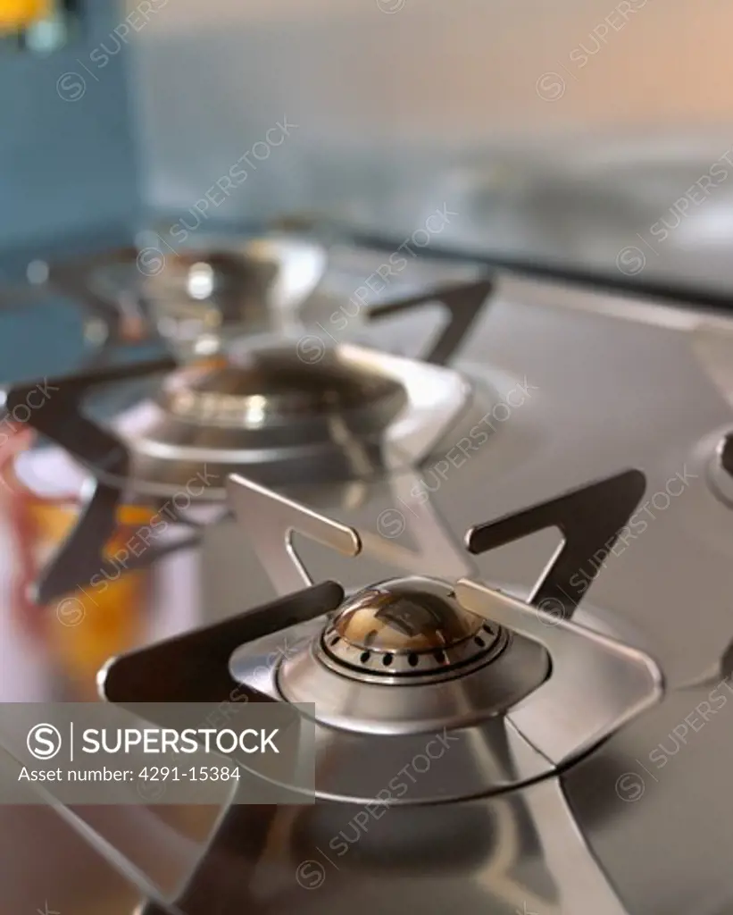 Close-up of gas jets on stainless steel hob